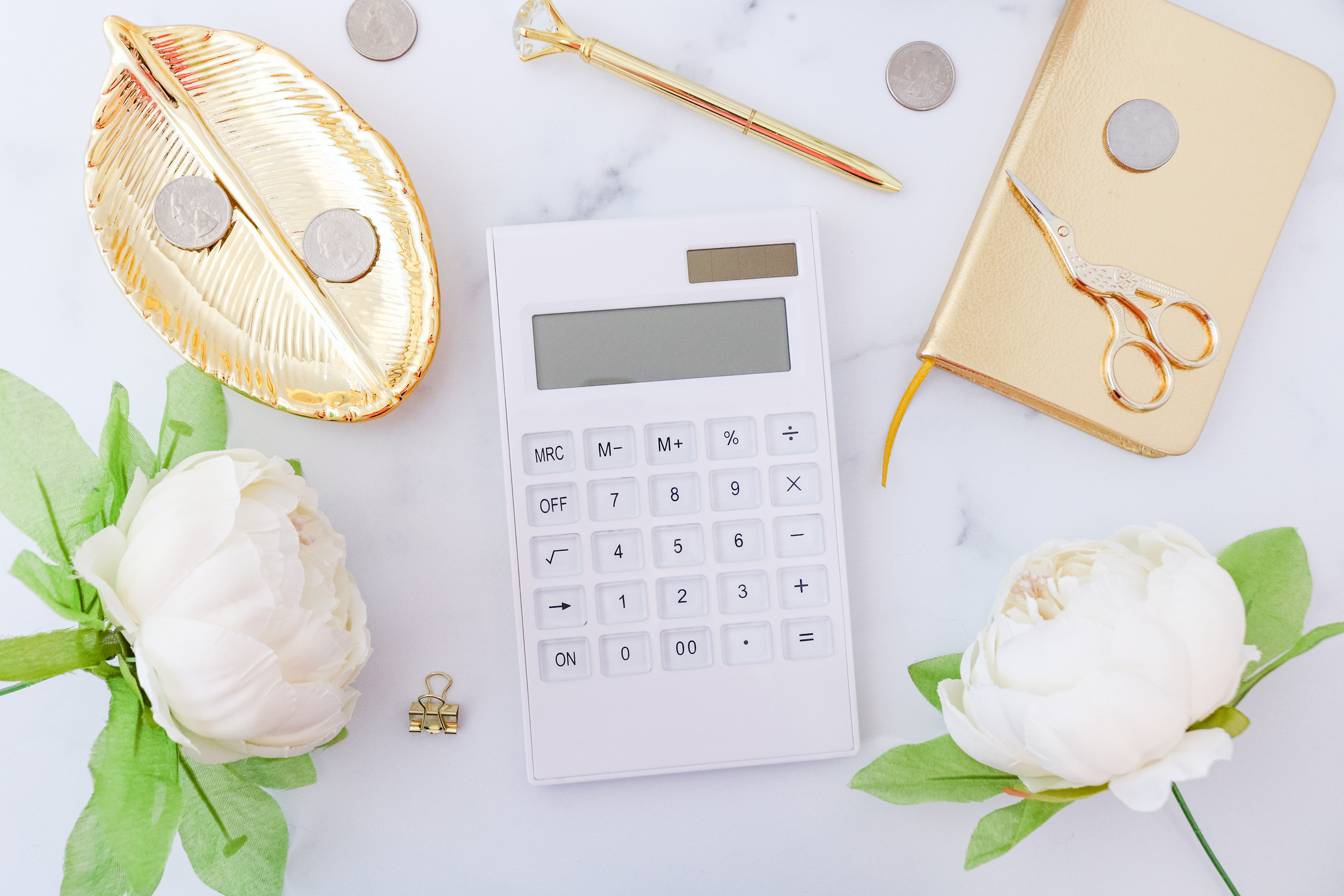 Calculator and Gold Office Supplies on Marble Desk 